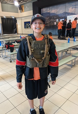 Photo of a youth wearing a police vest.