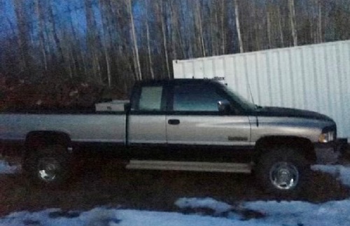 1996 green and silver Dodge 2500 pickup truck with running boards