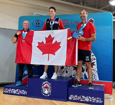 Reserve Constable Francoeur standing on podium with two other pickleball medalists